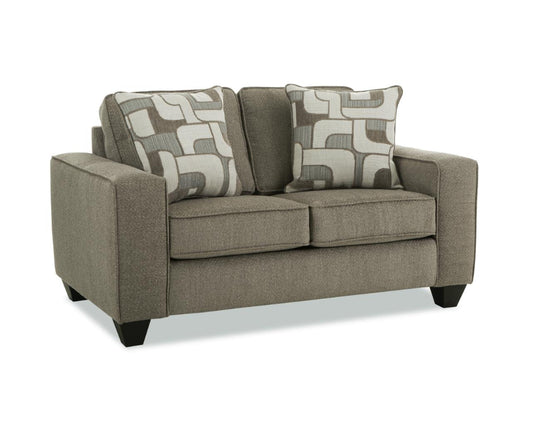 beige loveseat with patterned cushions on a white background