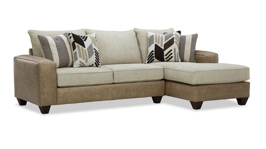 A beige and brown faux leather sofa chaise with accent pillows.