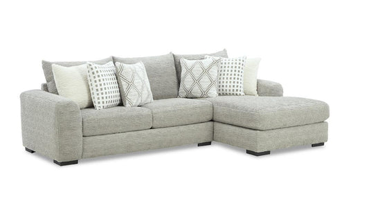 Gray sectional sofa with patterned cushions on a white background