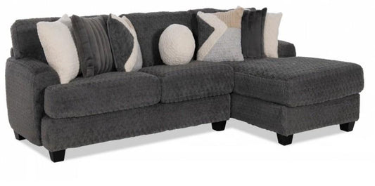 Gray sectional sofa with patterned cushions on a white background