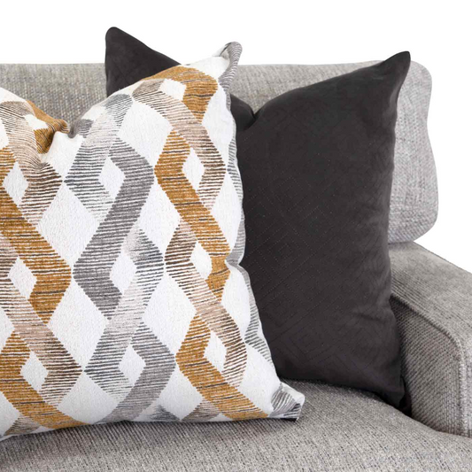 gold, gray, and white patterned pillow on gray sofa