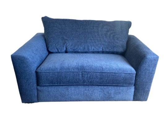 A blue twin sleeper chair with a pillow, showcasing its seating and sleeping functions.