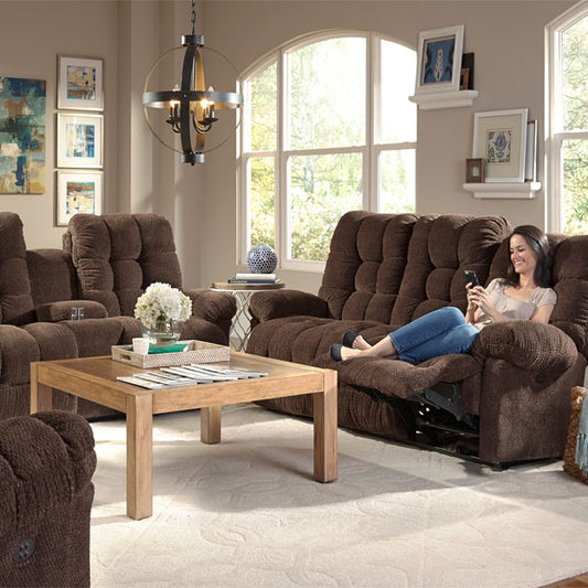 Living room with brown recliner sofa, wooden coffee table, and woman using a phone.