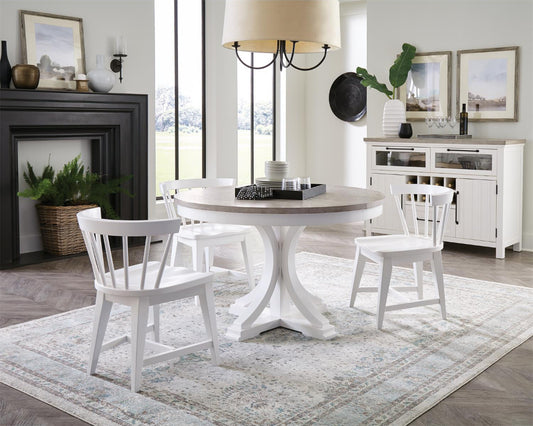 White round dining table with four chairs in a living room setting.