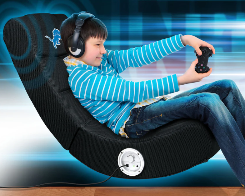 Child sitting in a black gaming chair with headphones and a controller, against a blue and white blurred background.