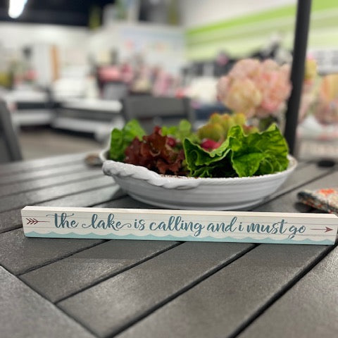 Decorative sign with text on a table with a blurred background