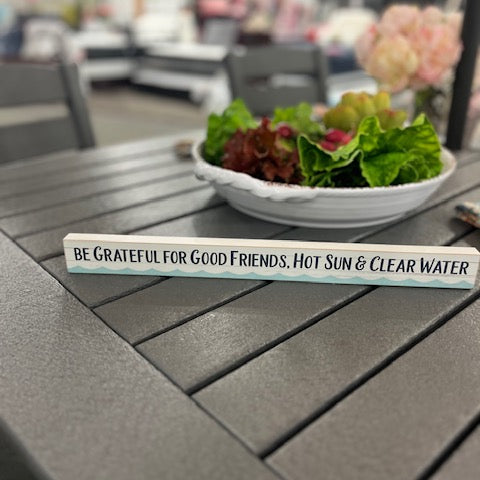 Table with a plate of salad and a motivational sign outdoors