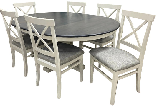 A round dining table with a gray tabletop and white X-back side chairs with gray cushions.