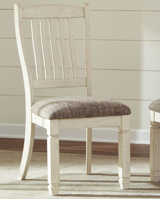 White wooden chair with a brown cushioned seat in a room with a neutral color scheme.