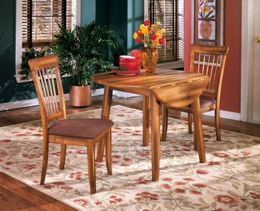 Wooden dining table with chairs on a floral rug in a home setting