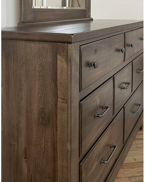Wooden dresser with multiple drawers and a mirror on top.