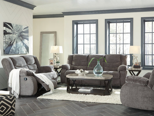 Gray reclining sofa set in a living room with decorative elements.
