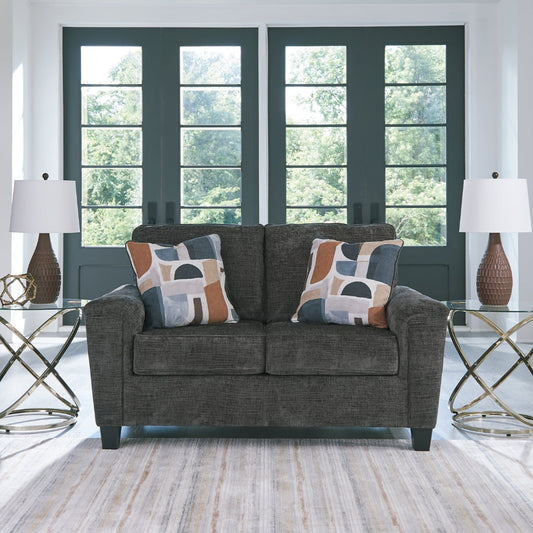 Living room with a gray loveseat, decorative pillows, and two side tables with lamps.