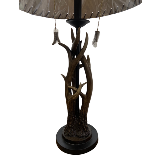 Decorative lamp with branch-like design and brown lampshade on a white background