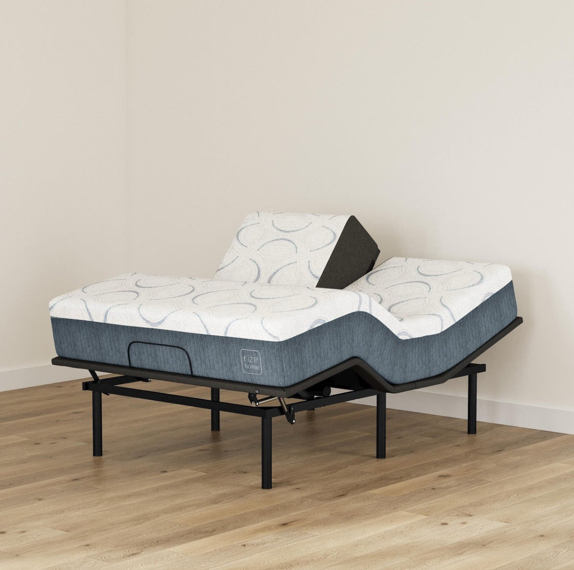 Adjustable bed with mattress and pillow on a wooden floor against a beige wall