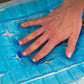 Hand pressing into a blue gel