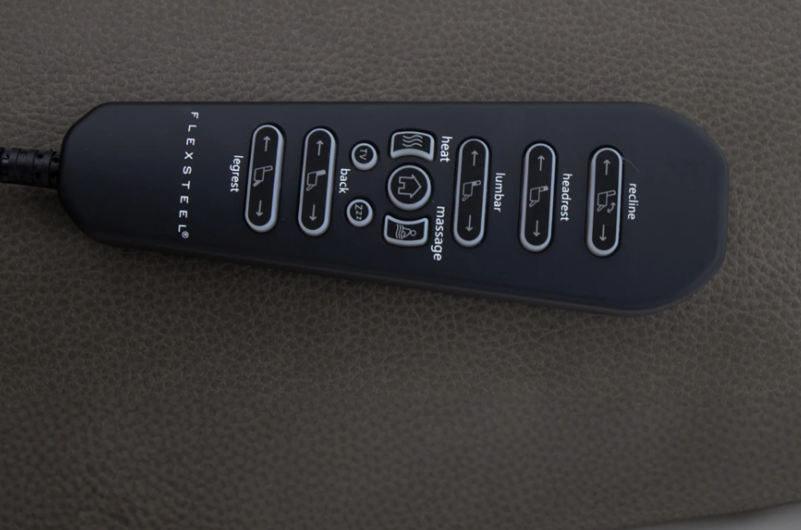 Black massage remote control on a textured gray surface