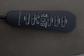 Black massage remote control on a textured gray surface
