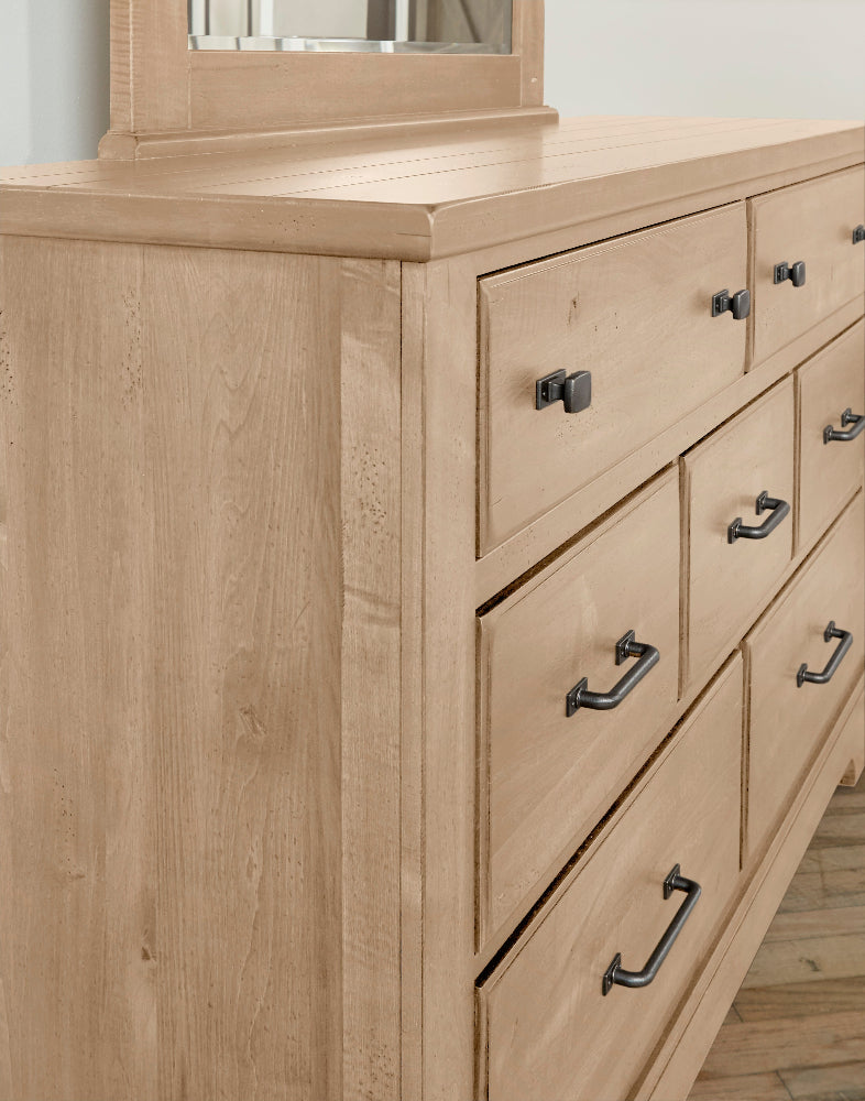 Wooden dresser with multiple drawers and metal handles on a light background