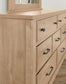 Wooden dresser with multiple drawers and metal handles on a light background