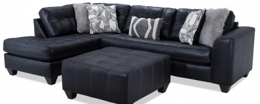 Black leather sectional sofa with patterned cushions on a white background