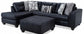 Black leather sectional sofa with patterned cushions on a white background