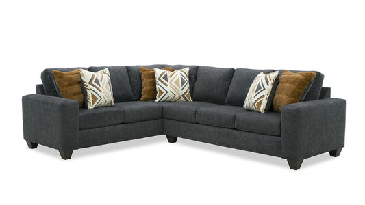 A charcoal gray sectional sofa with geometric-print ottoman and accent pillows in various patterns.