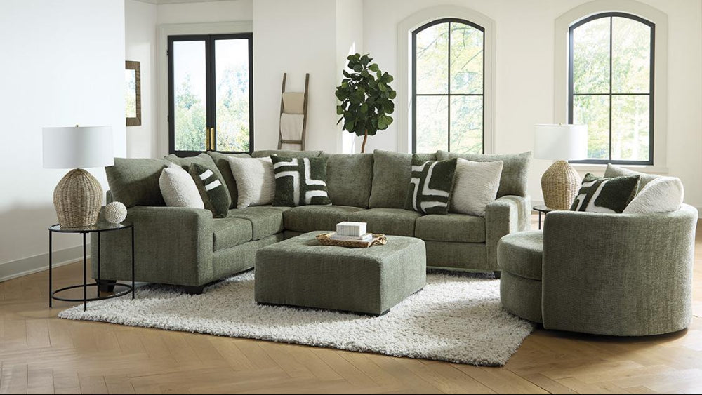Modern living room with a green sectional sofa, armchair, and ottoman.