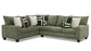 Green sectional sofa with patterned cushions on a white background