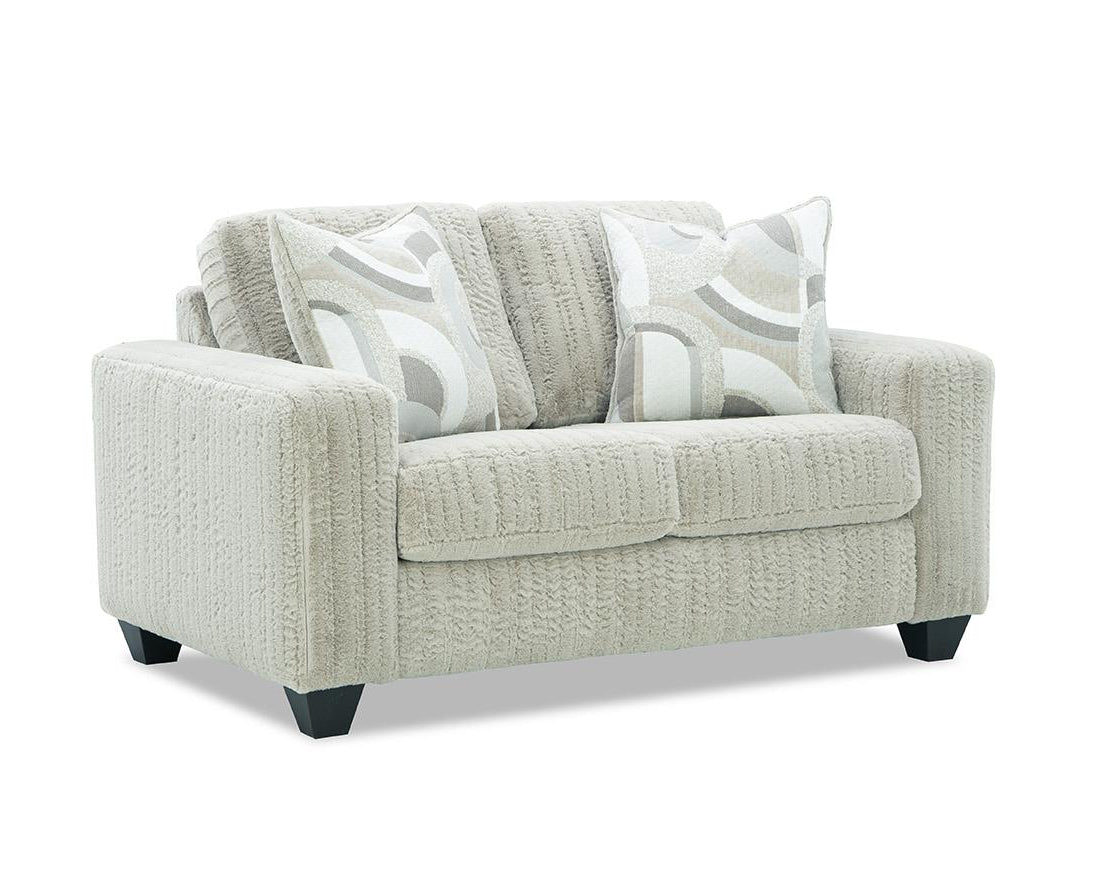 cream loveseat with patterned cushions on a white background