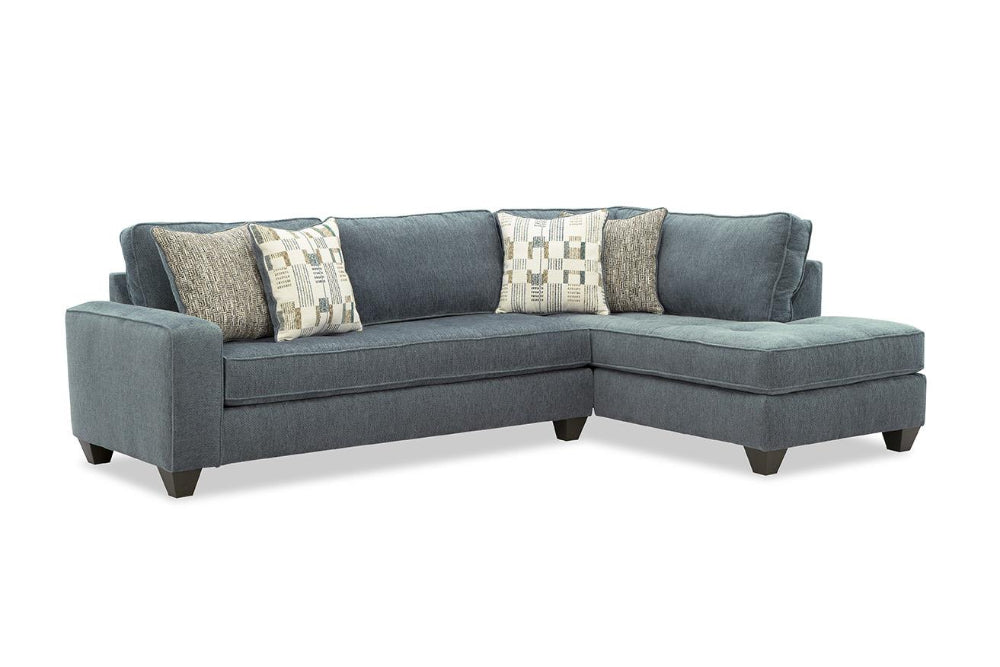 Gray sectional sofa with patterned cushions on a white background