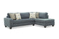 Gray sectional sofa with patterned cushions on a white background