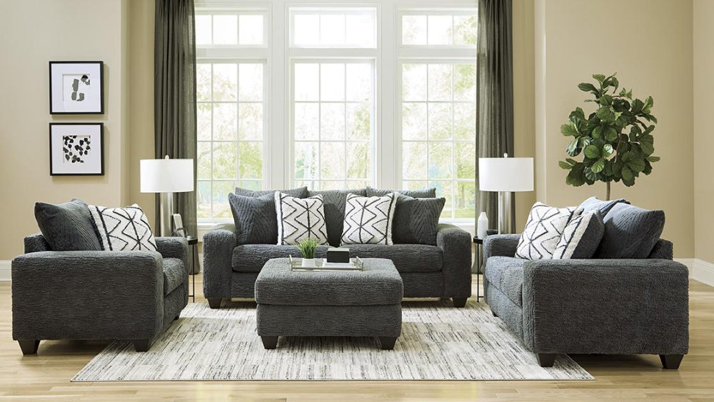 Living room with gray sofa set, ottoman, and decor elements.