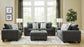 Living room with gray sofa set, ottoman, and decor elements.