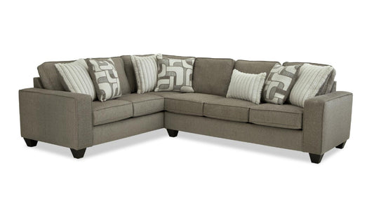 Gray sectional sofa with patterned cushions on a white background