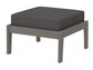 A dark gray cushioned deep seating ottoman with a driftwood frame, made from all-weather materials suitable for outdoor use.