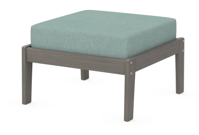 A light blue cushioned deep seating ottoman with a driftwood frame, made from all-weather materials suitable for outdoor use.