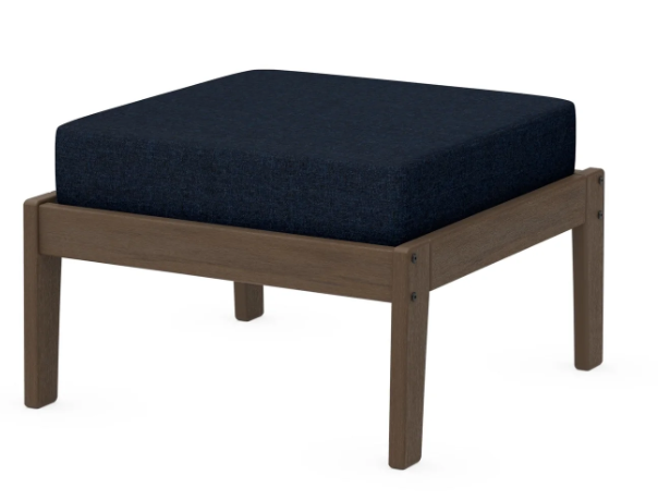 A navy cushioned deep seating ottoman with a kona frame, made from all-weather materials suitable for outdoor use.