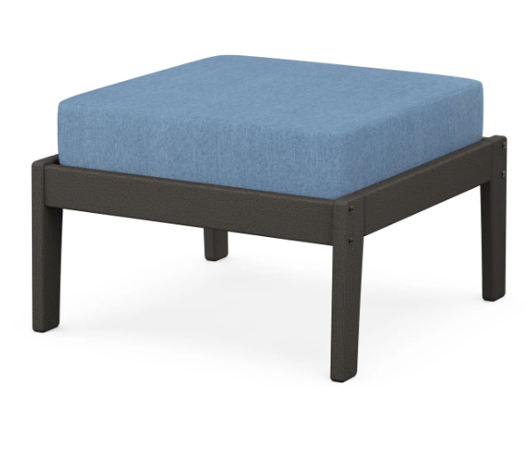 A blue cushioned deep seating ottoman with a vintage coffee frame, made from all-weather materials suitable for outdoor use.