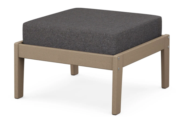 A dark gray cushioned deep seating ottoman with a vintage sahara frame, made from all-weather materials suitable for outdoor use.