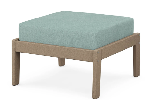 A light blue cushioned deep seating ottoman with a vintage sahara frame, made from all-weather materials suitable for outdoor use.