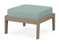 A light blue cushioned deep seating ottoman with a vintage sahara frame, made from all-weather materials suitable for outdoor use.