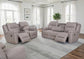 Gray reclining sofa set in a living room with large windows and a rug.