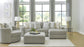 Living room with gray sectional sofa, ottoman, and decorative pillows.