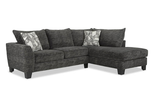 Gray sectional sofa with patterned cushions on a white background