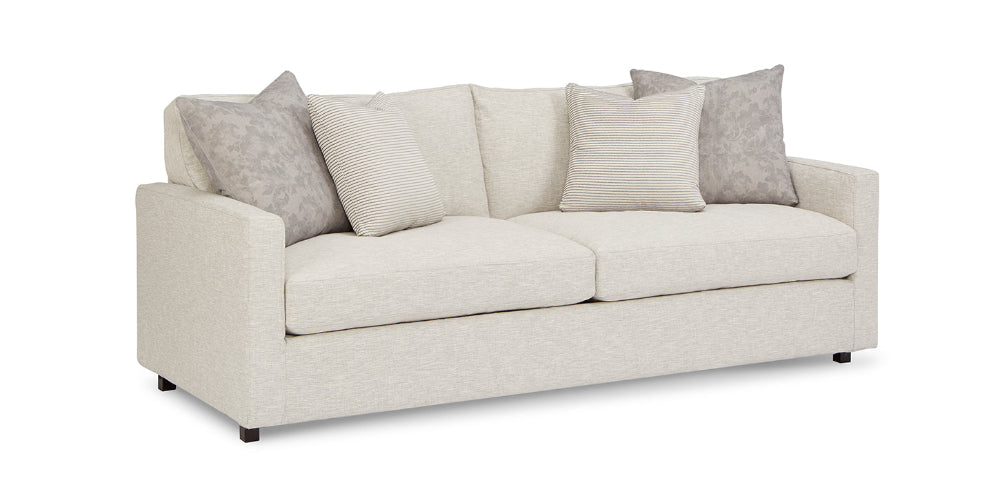 Beige sofa with decorative pillows on a white background