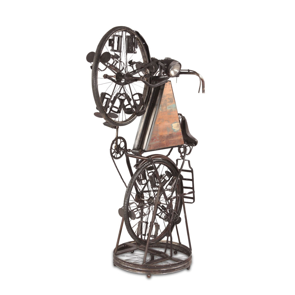 Decorative metal sculpture of a person on a bicycle with gears and a triangular panel.