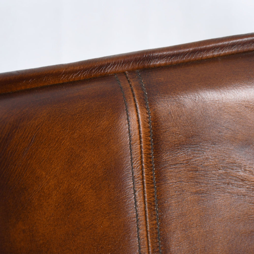 Close-up of brown leather surface with visible stitching