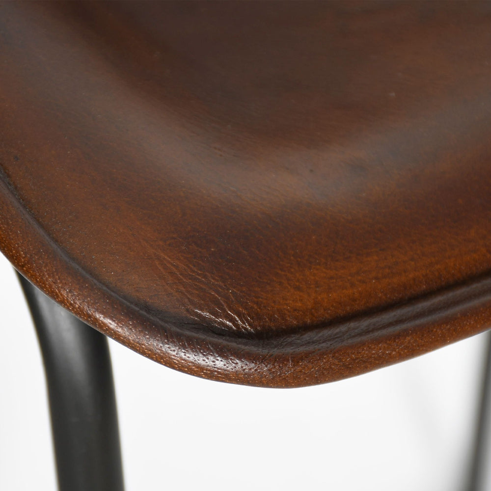 Close-up of a brown leather stool seat on a white background