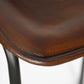 Close-up of a brown leather stool seat on a white background